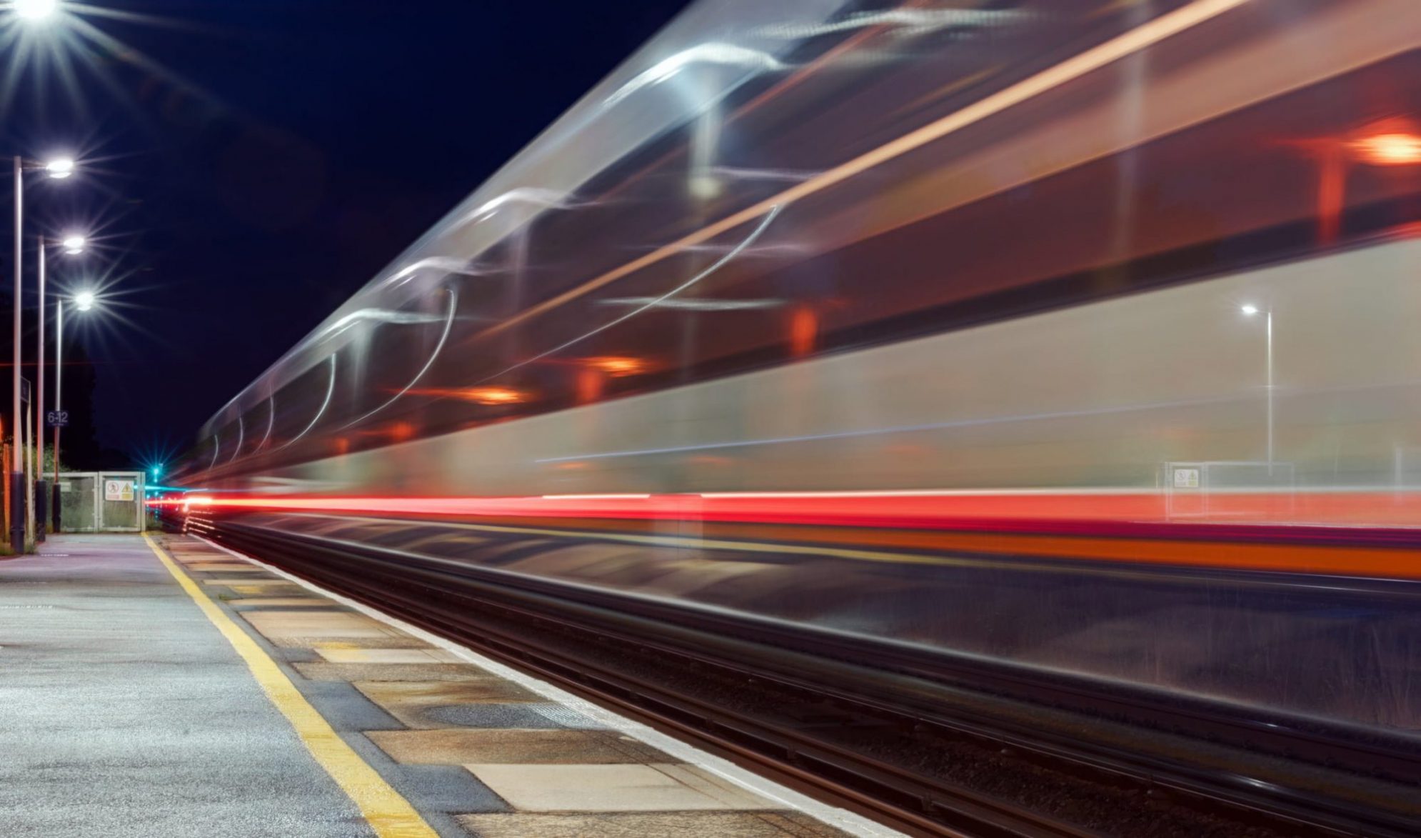 Train passing through a UK station at high speed captured as motion blur